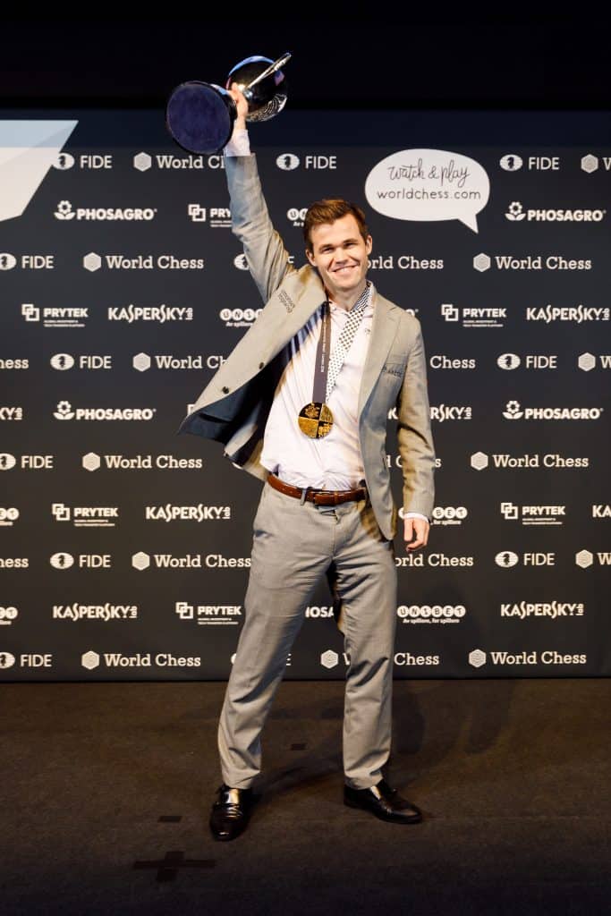 Magnus Carlsen holds the trophy aloft
